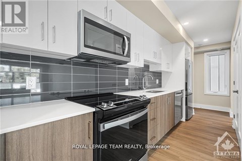 A modern kitchen with a stove top oven and microwave above it.