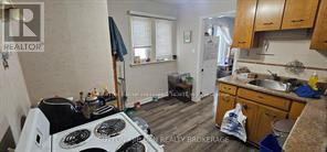 A kitchen with a stove top oven and wooden cabinets.