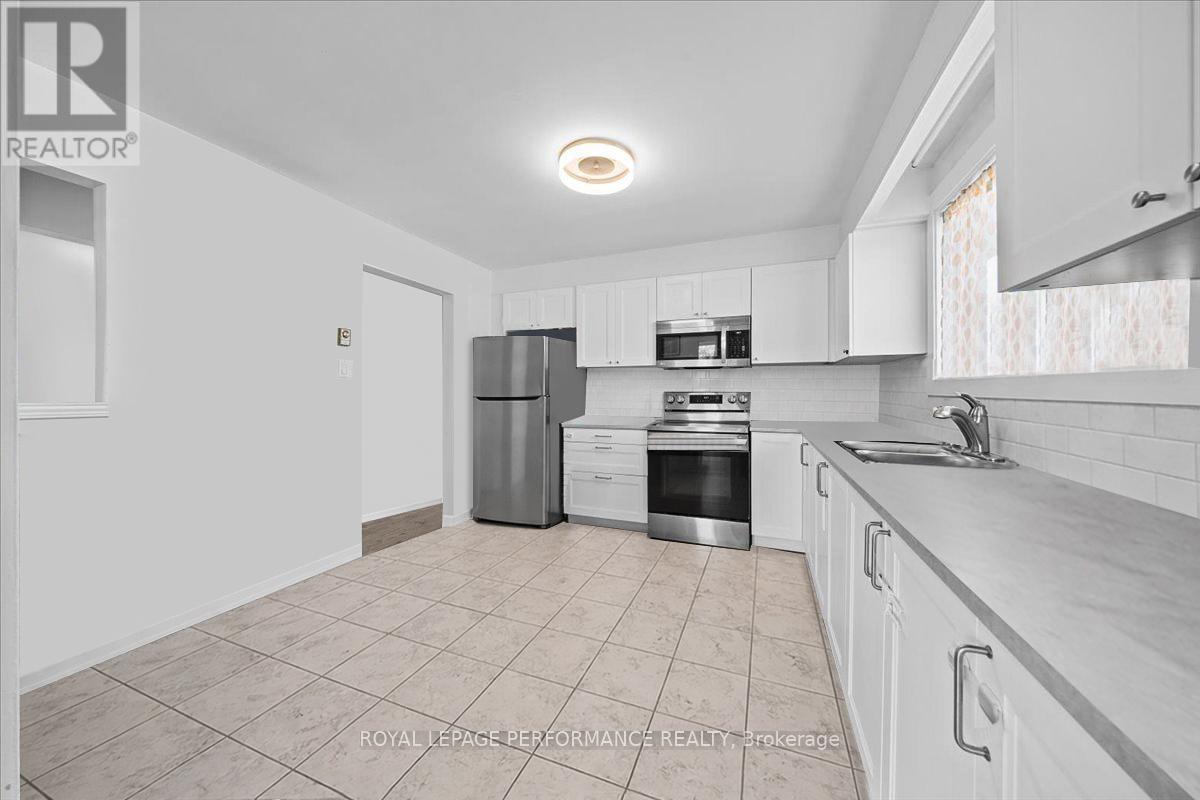 A kitchen with white cabinets and a tiled floor.