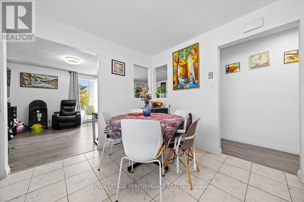 A dining room with a table set for two and a painting on the wall.