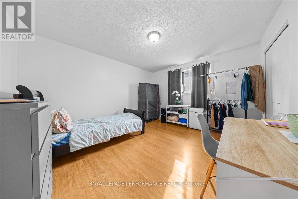 A bedroom with a bed, desk, and closet.