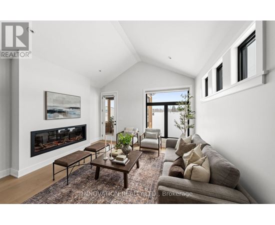 A modern living room with a fireplace and a large painting on the wall.