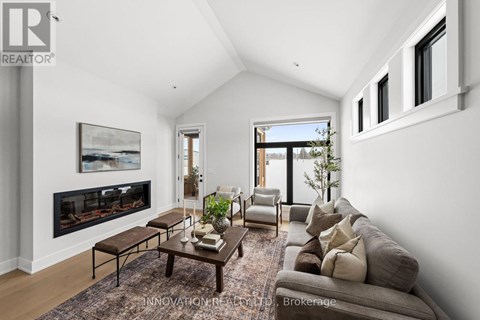 A modern living room with a fireplace and a large painting on the wall.