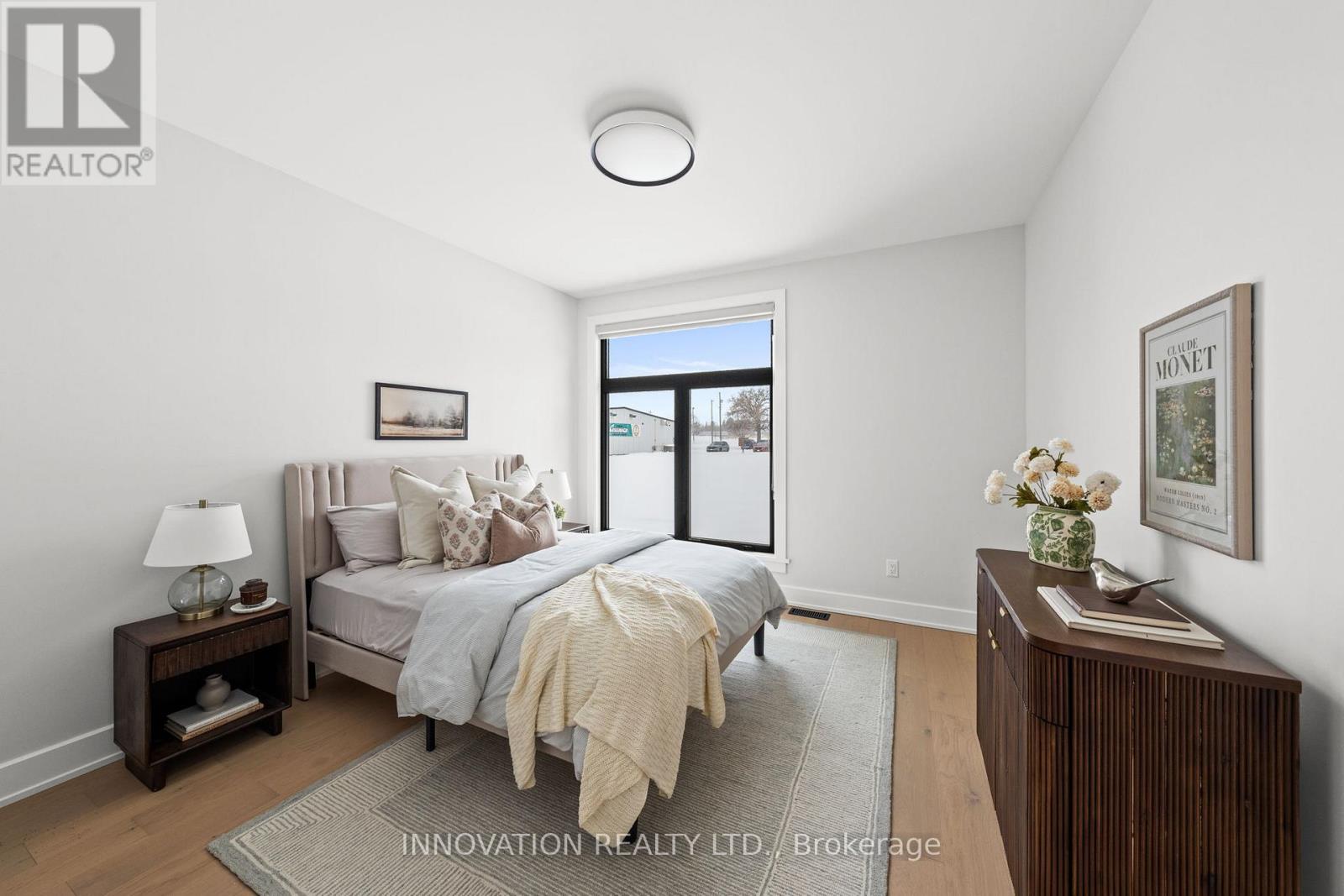 A bedroom with a bed, nightstand, and lamp.