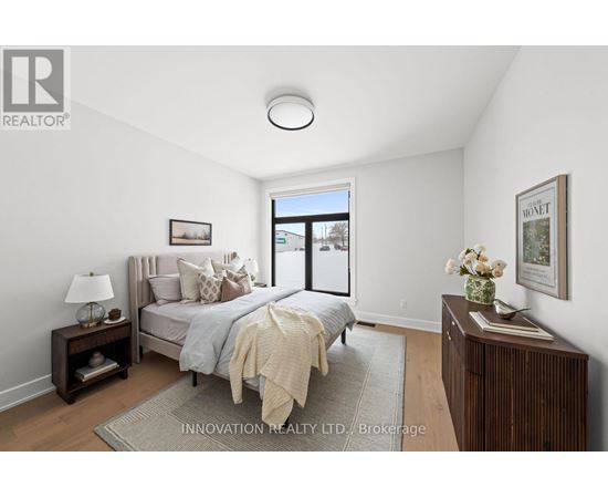 A bedroom with a bed, nightstand, and lamp.