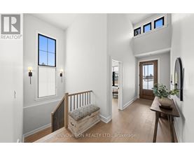 A well-lit, spacious hallway with a bench and a potted plant.