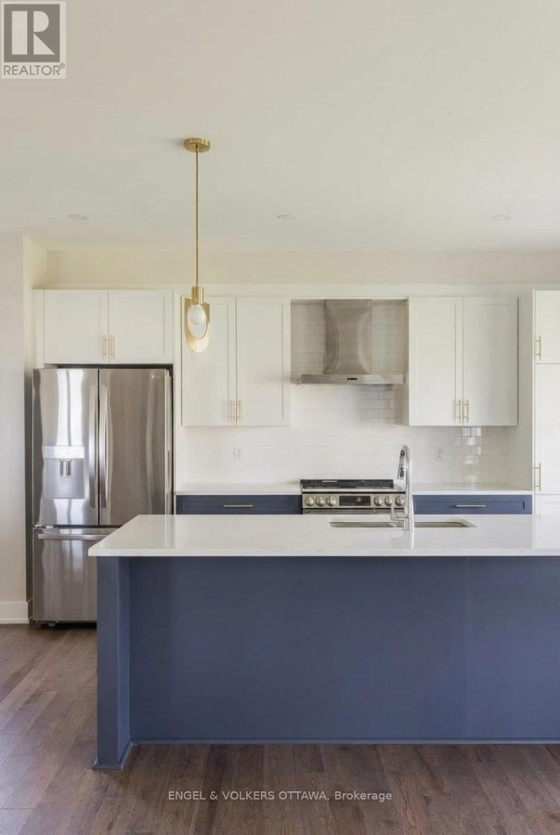 A kitchen with a stainless steel refrigerator and a sink with a countertop.