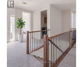 A well-lit, spacious hallway with a wooden railing and a potted plant.