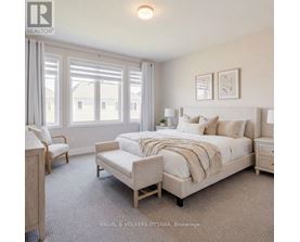 A bedroom with a large bed and a window with curtains.