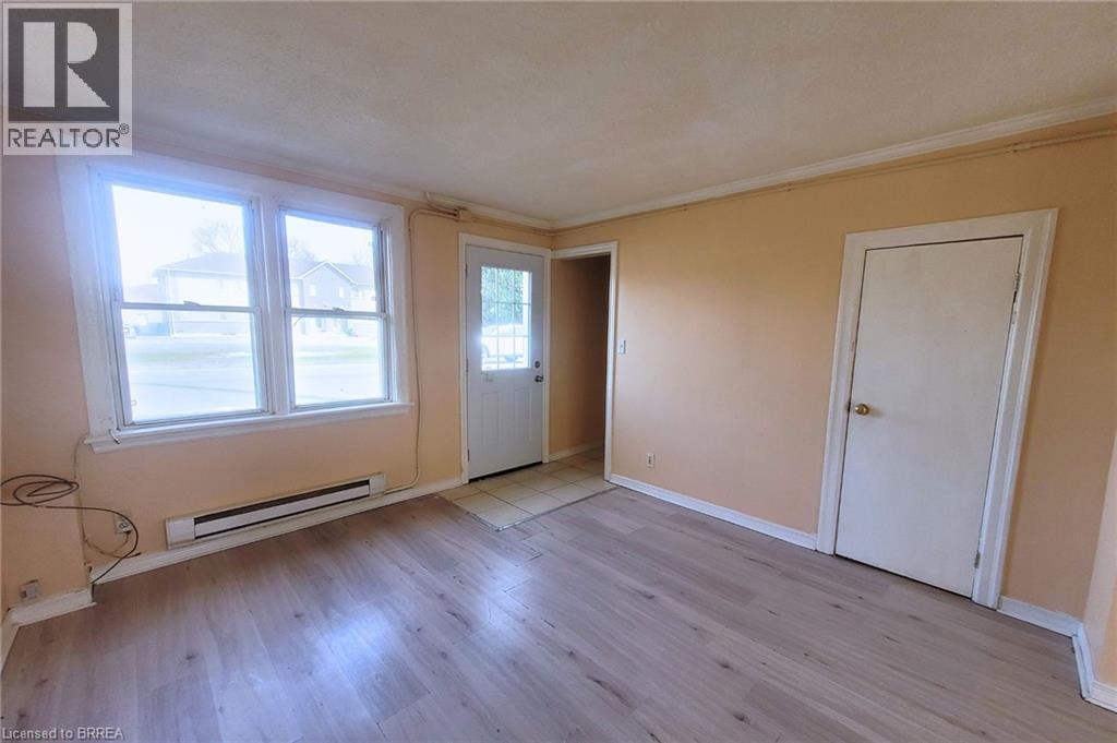A room with a window, a door, and a wall with a window.