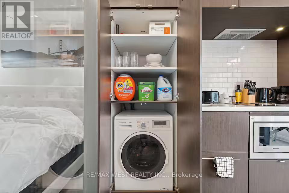 A small kitchen with a washing machine built into the wall.