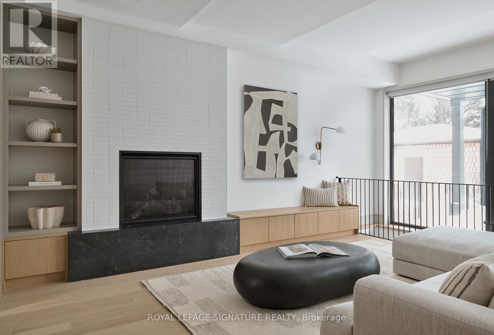 A modern living room with a fireplace and a large abstract painting above it.