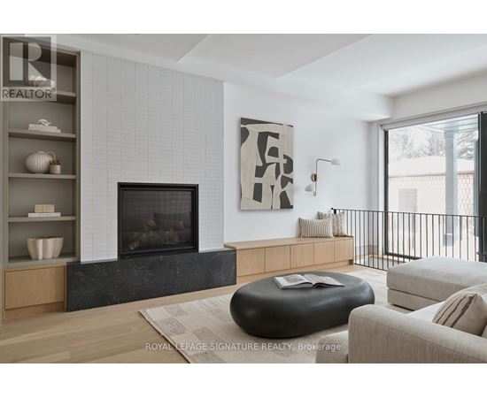 A modern living room with a fireplace and a large abstract painting above it.