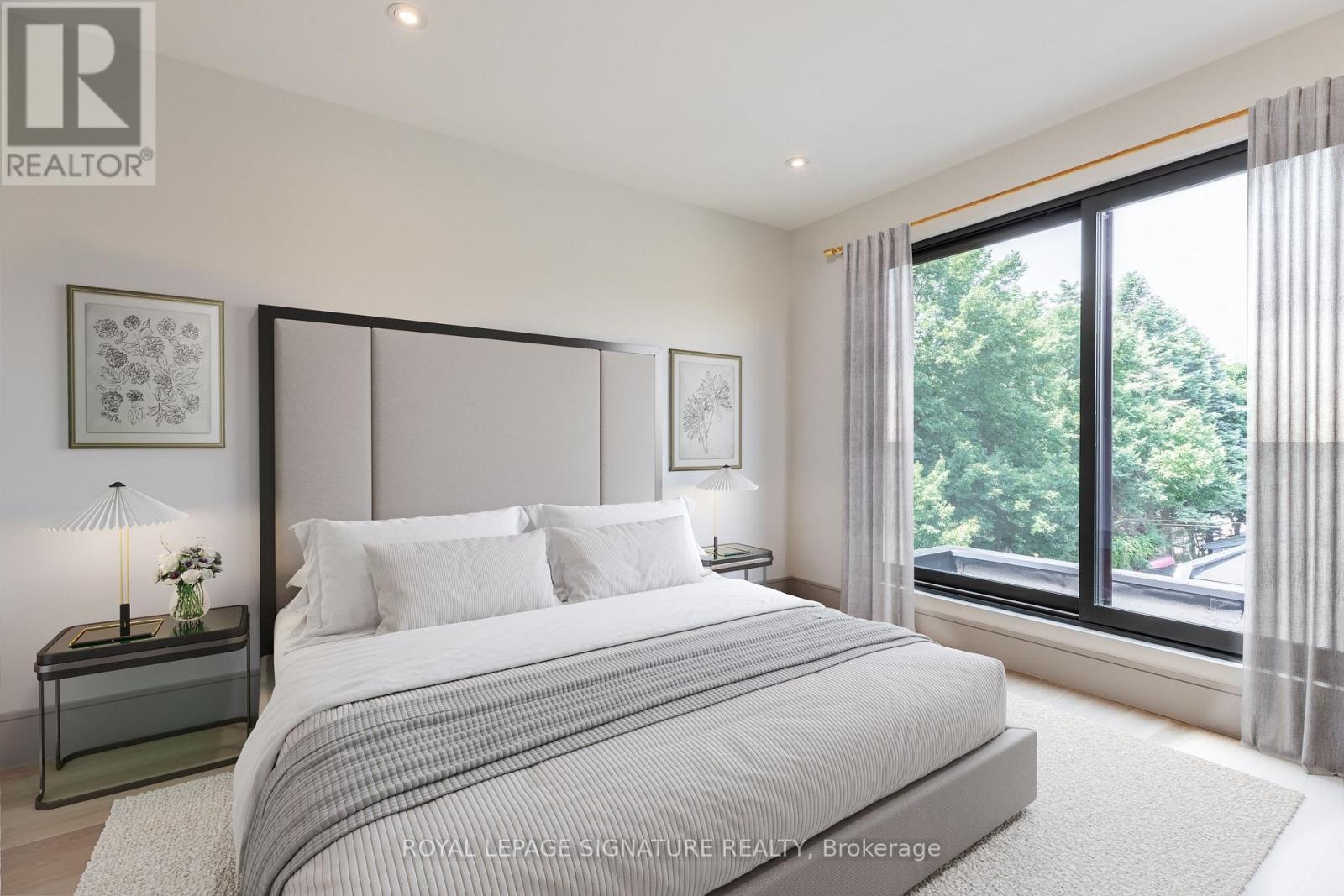 A bedroom with a large bed and a window overlooking a street.