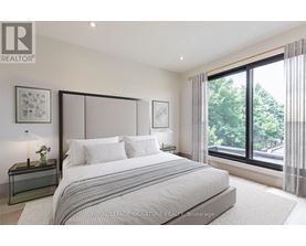 A bedroom with a large bed and a window overlooking a street.