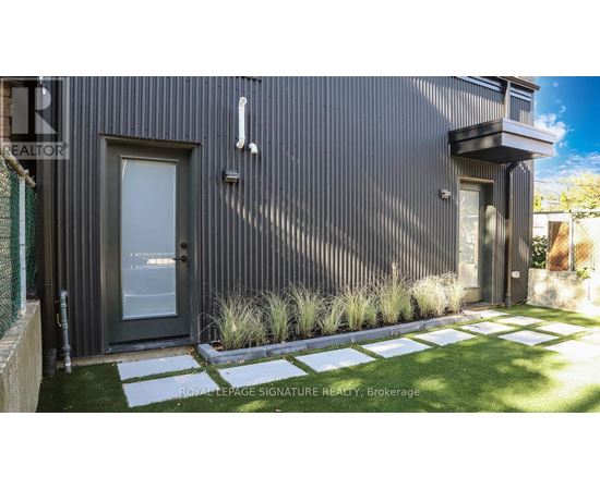 A modern house with a grey exterior and a glass door.