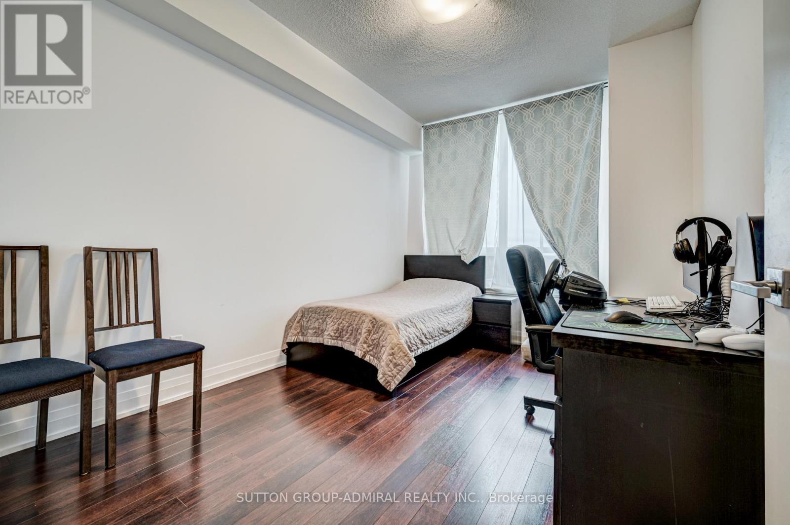 A bedroom with a bed, desk, and chair.