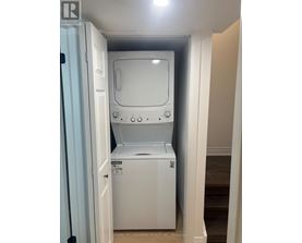A white dishwasher is in a small space between a door and a wall.
