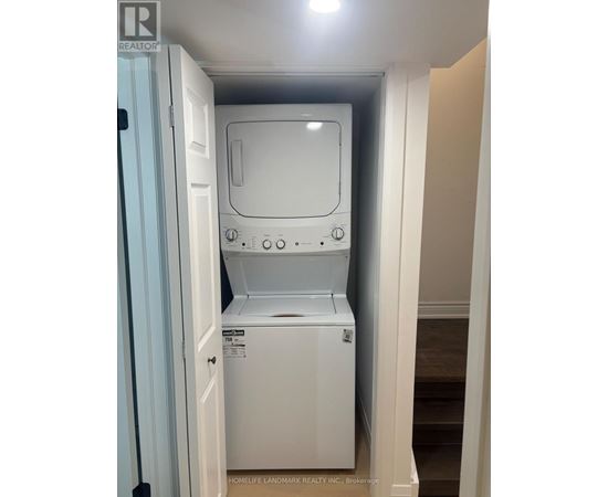 A white dishwasher is in a small space between a door and a wall.