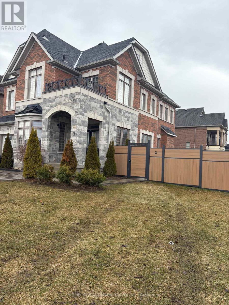 A large house with a stone archway entrance and a fence.