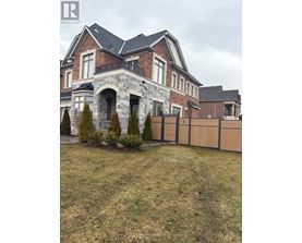 A large house with a stone archway entrance and a fence.