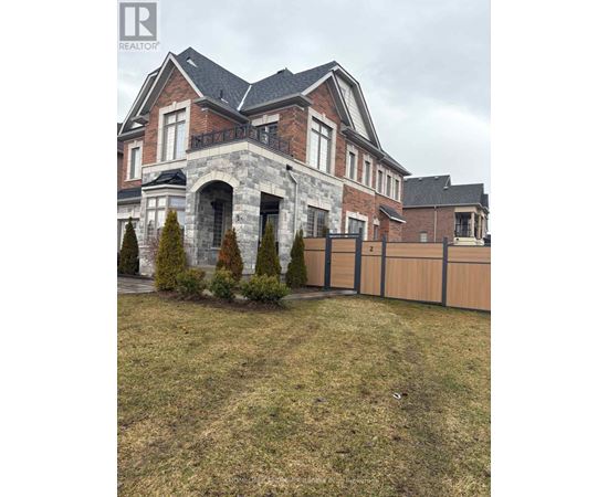 A large house with a stone archway entrance and a fence.