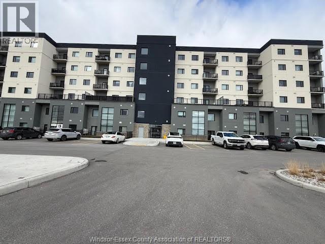 A large apartment complex with a parking lot in front.