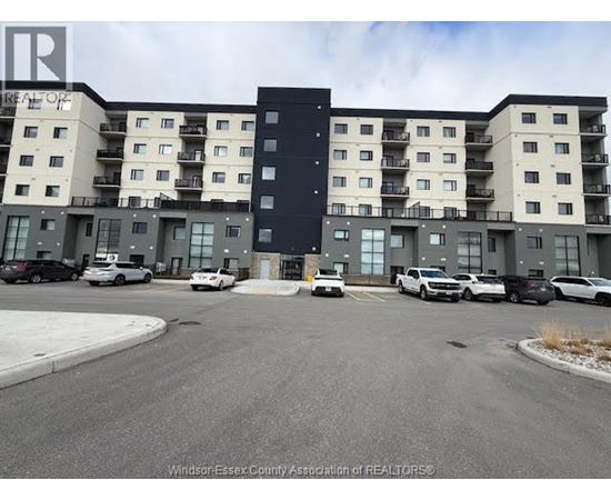 A large apartment complex with a parking lot in front.