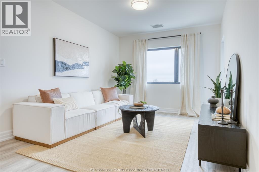 A living room with a white couch, a coffee table, and a painting on the wall.