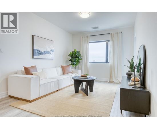 A living room with a white couch, a coffee table, and a painting on the wall.