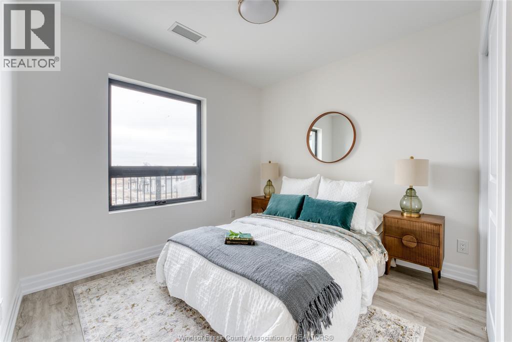 A bedroom with a bed, nightstand, and window.