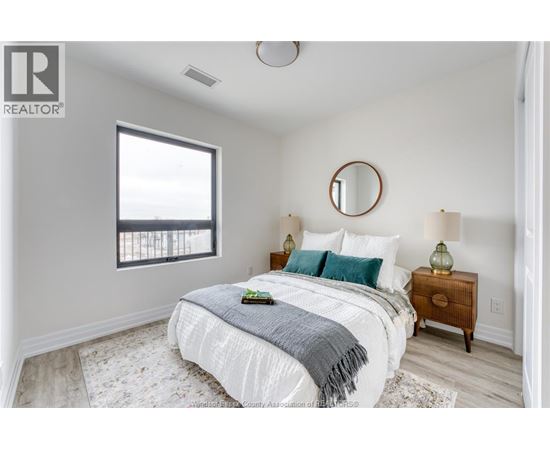 A bedroom with a bed, nightstand, and window.