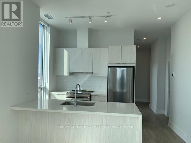 A modern kitchen with white cabinets and a stainless steel refrigerator.