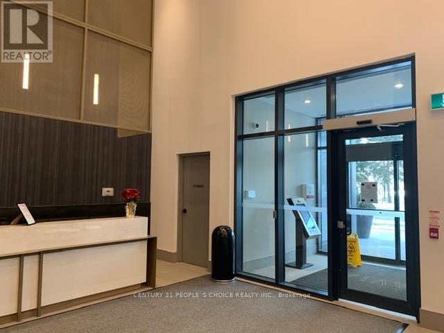 A reception area with a white counter and a glass door leading outside.