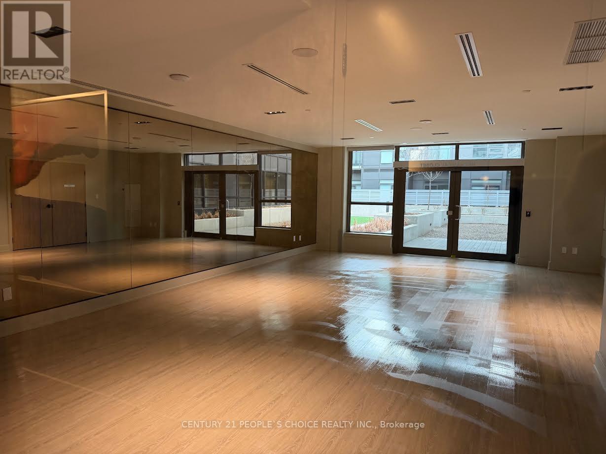 A spacious room with wooden floors and large windows.