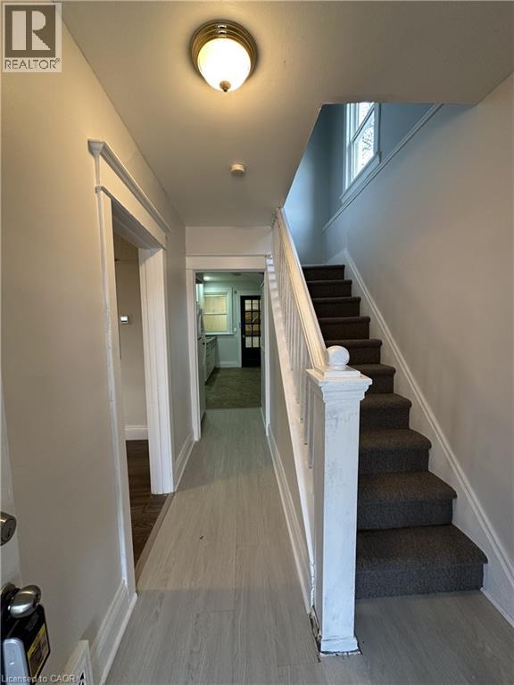 A hallway with a staircase and a light on the ceiling.