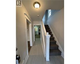 A hallway with a staircase and a light on the ceiling.