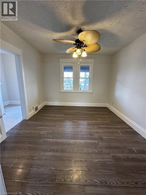 A room with wood flooring and a ceiling fan.