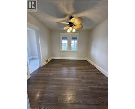 A room with wood flooring and a ceiling fan.