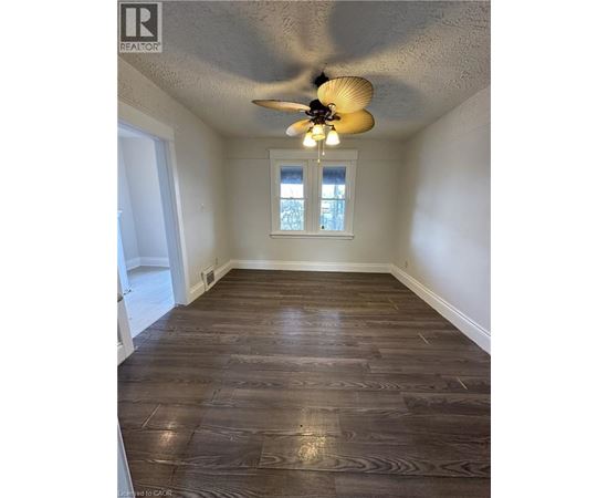 A room with wood flooring and a ceiling fan.