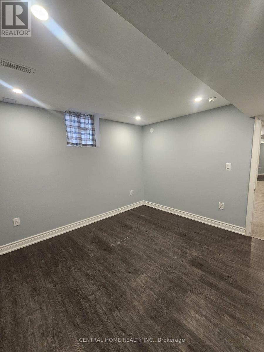 A room with a window and a wooden floor.