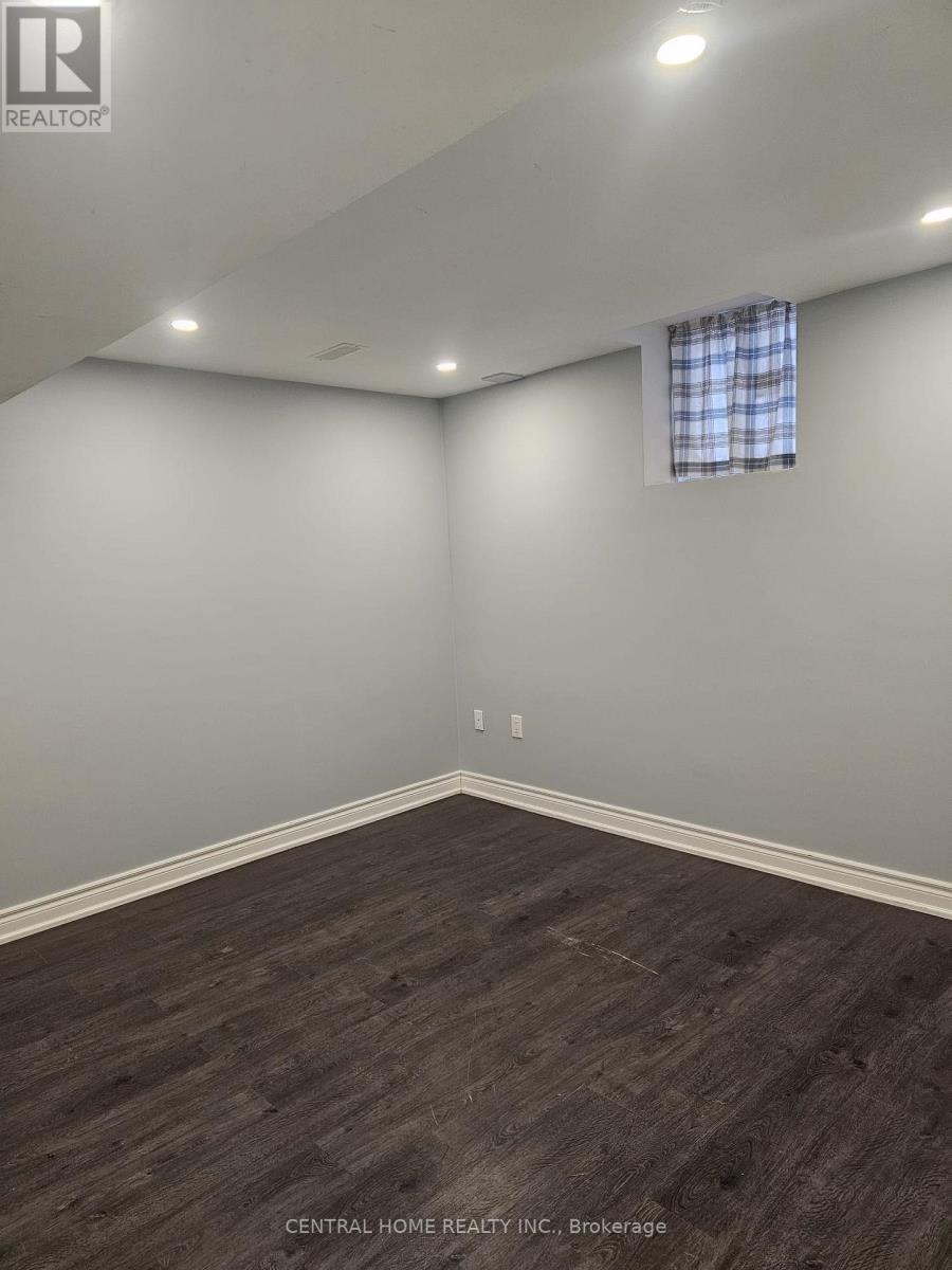 A room with a window and a wooden floor.