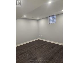 A room with a window and a wooden floor.