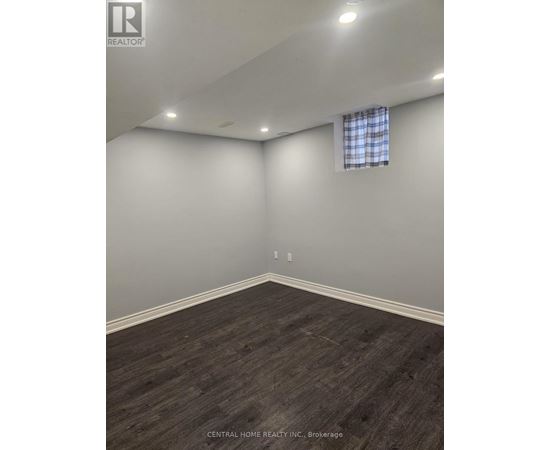 A room with a window and a wooden floor.