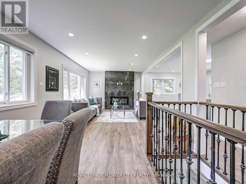 A well-lit, spacious living room with a leather sofa and a fireplace.