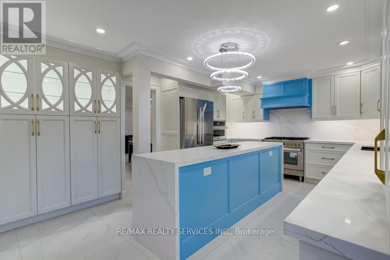 A modern kitchen with white cabinets and a blue island.