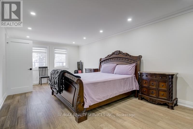 A bedroom with a large bed and a wooden chest of drawers.