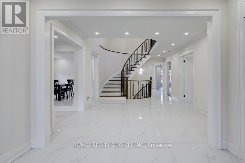 A spacious hallway with a staircase and a dining table.