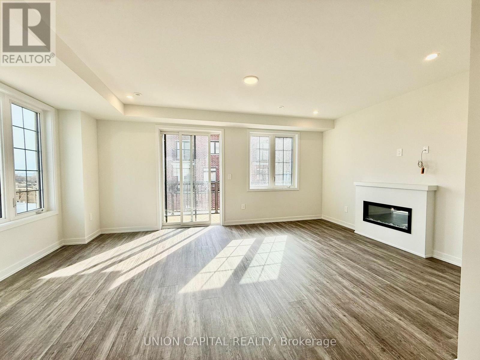 A spacious room with wood flooring and a fireplace is on the market.