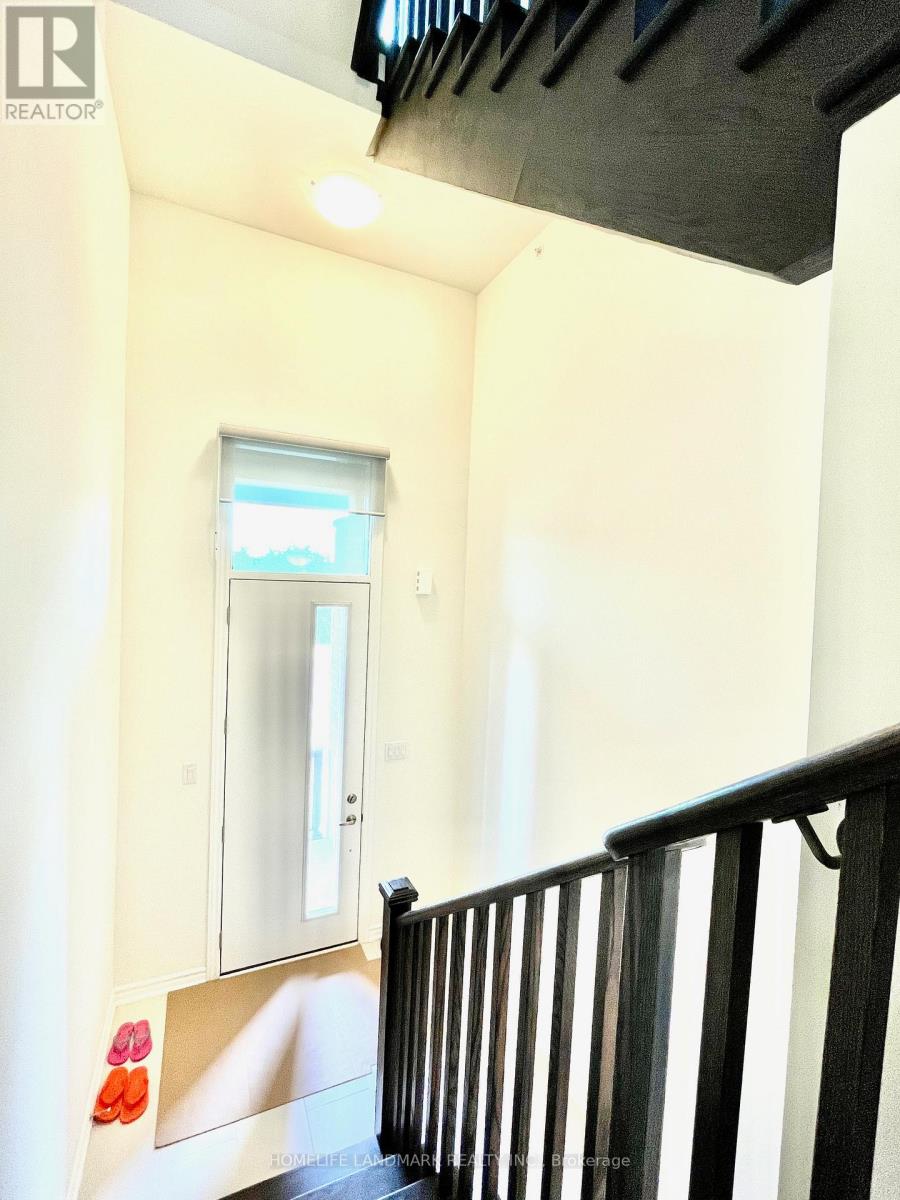 A hallway with a black railing and a window.